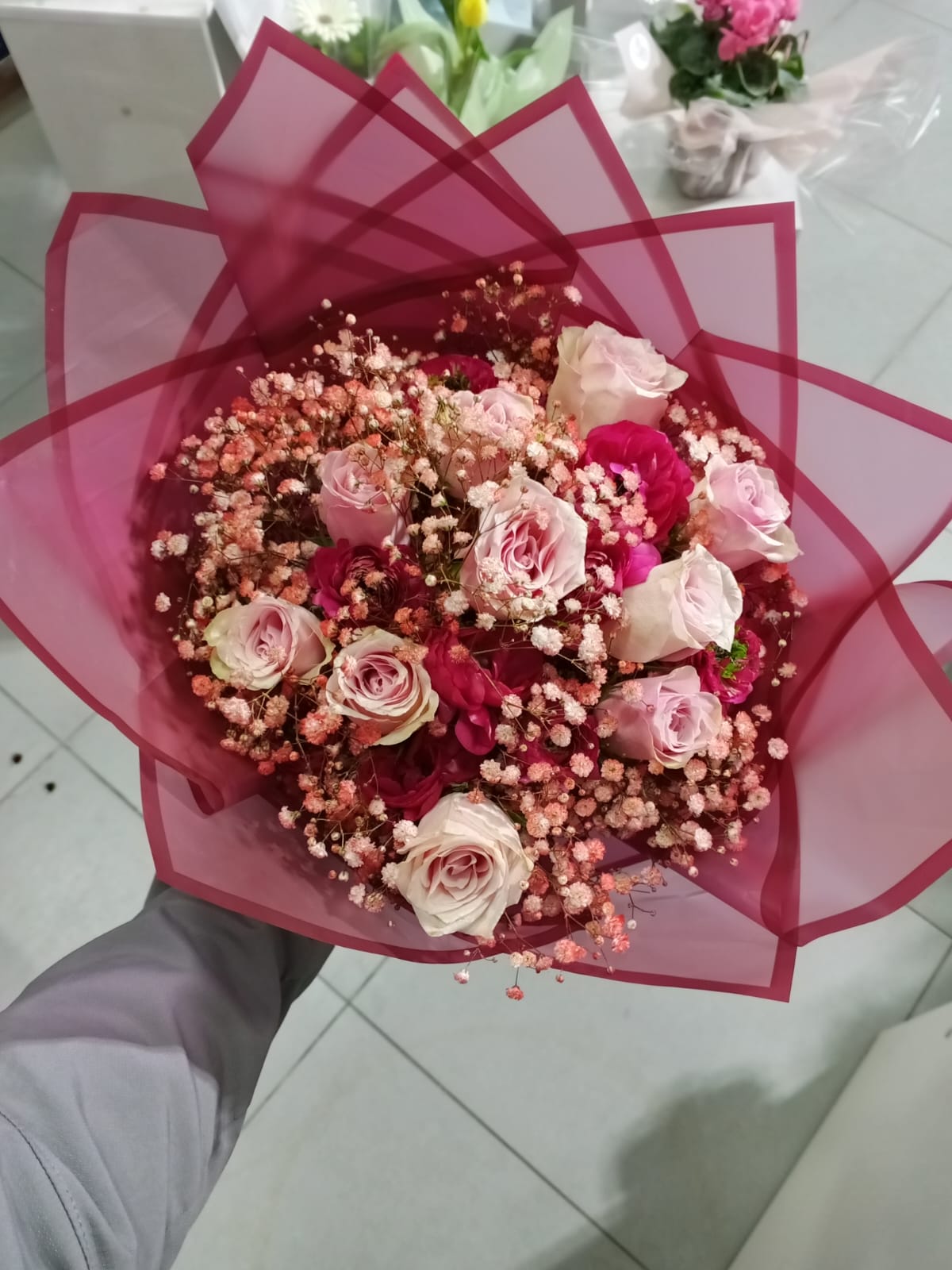 Pink and red roses with pink baby's breath in pink wrapper
